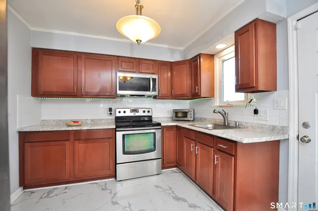 a kitchen with stainless steel appliances granite countertop a stove top oven a sink dishwasher and a microwave oven on the blue kitchen countertops