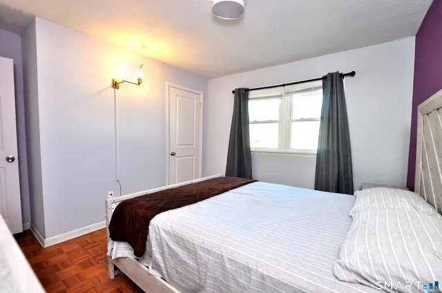 a bedroom with a bed and a window