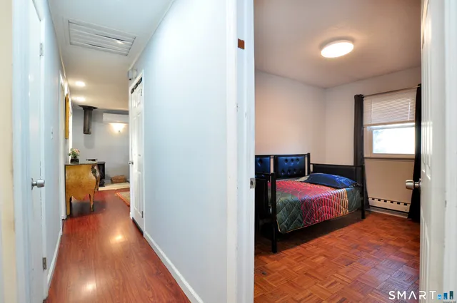 a view of a bedroom with bed and wooden floor