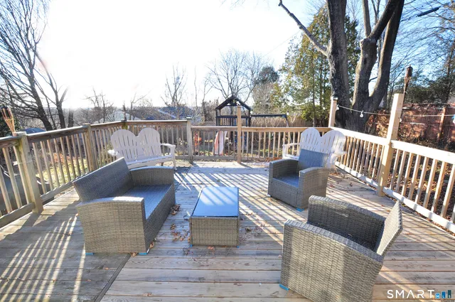a view of a deck with two couches chairs and wooden floor