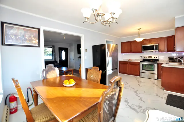 a kitchen with stainless steel appliances granite countertop a dining table and chairs