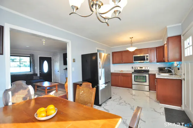 a large kitchen with stainless steel appliances granite countertop a stove refrigerator and cabinets