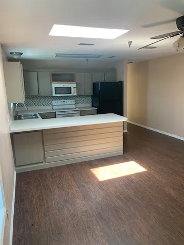 a view of kitchen with kitchen island a sink and a refrigerator