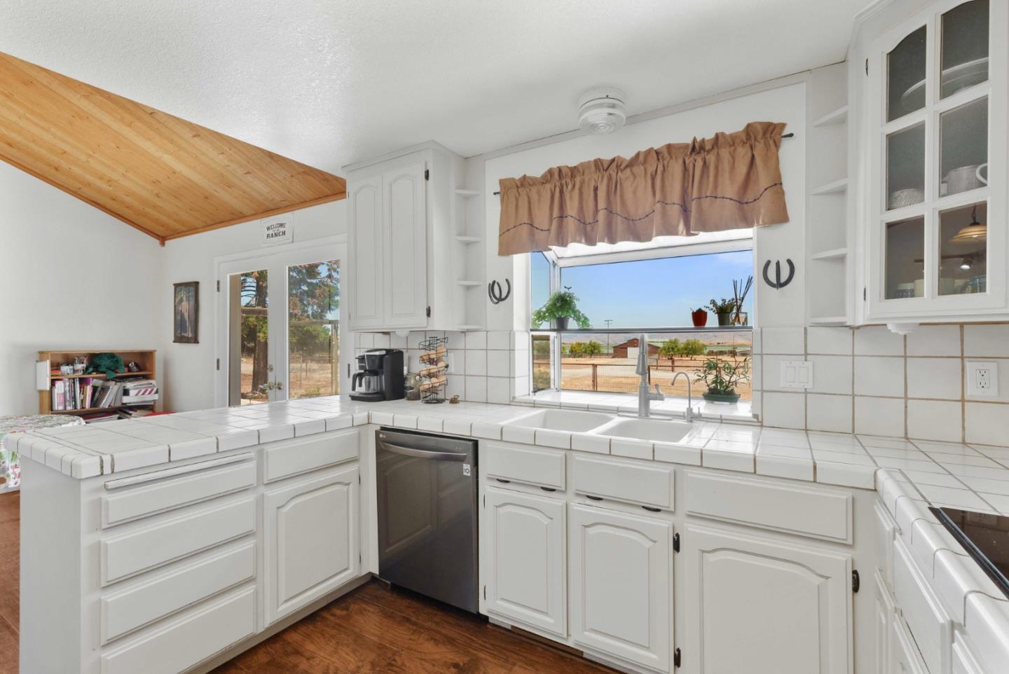 1150 Wright Road Hollister, CA 95023 - Photo 35 of 68 a kitchen with white cabinets and a window