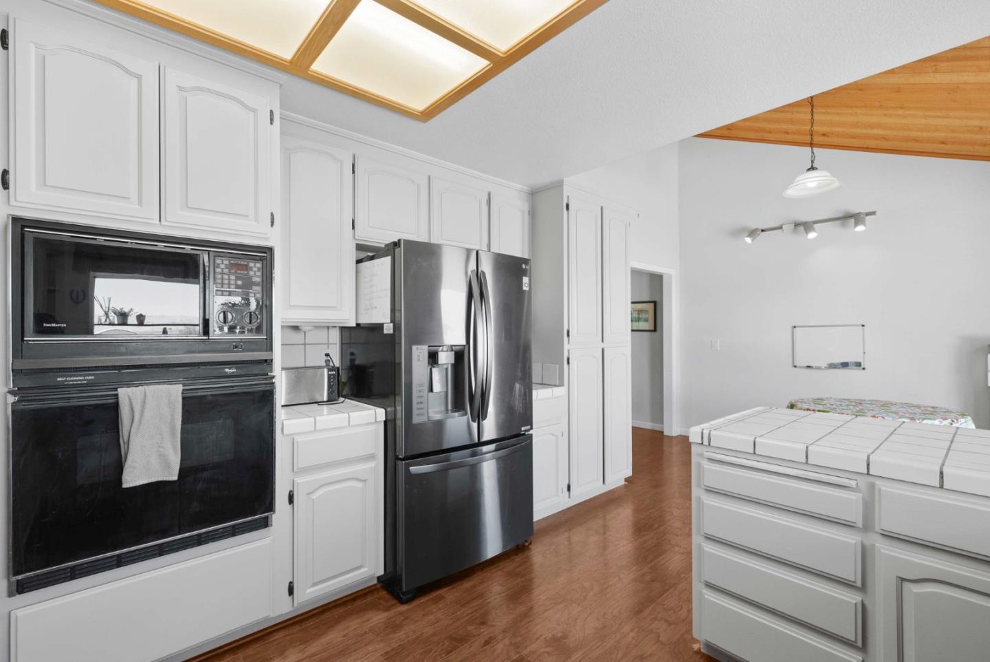 1150 Wright Road Hollister, CA 95023 - Photo 36 of 68 a kitchen with a refrigerator stove and white cabinets