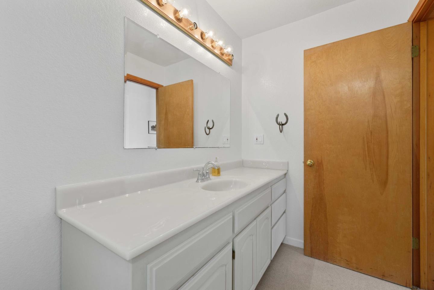 1150 Wright Road Hollister, CA 95023 - Photo 60 of 68 a bathroom with a sink a vanity and a mirror