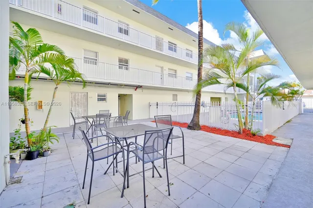 a view of a patio with table and chairs and potted plants
