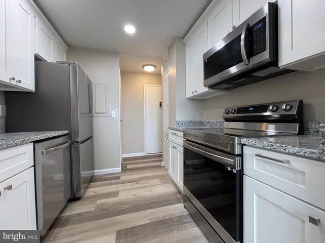 a kitchen with stainless steel appliances granite countertop a stove microwave and refrigerator