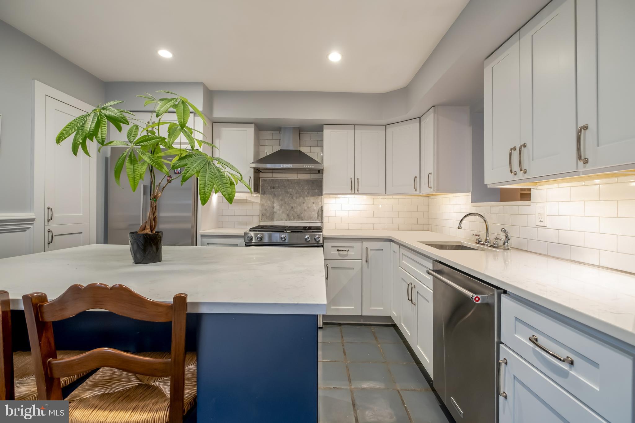 a kitchen with stainless steel appliances granite countertop a sink a stove and a refrigerator