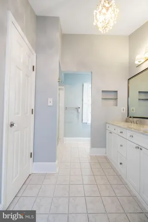a spacious bathroom with a granite countertop sink a mirror and a vanity
