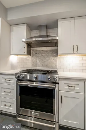 a stove top oven sitting inside of a kitchen