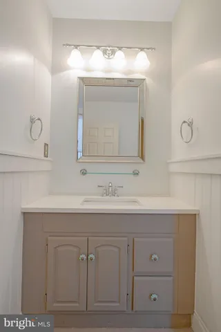 a bathroom with a sink vanity and mirror