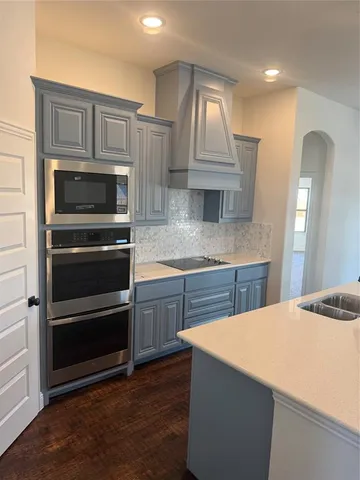 a kitchen with kitchen island granite countertop a stove and a sink