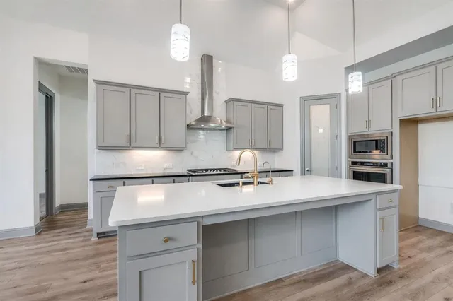 a kitchen with stainless steel appliances granite countertop a sink a stove and a refrigerator