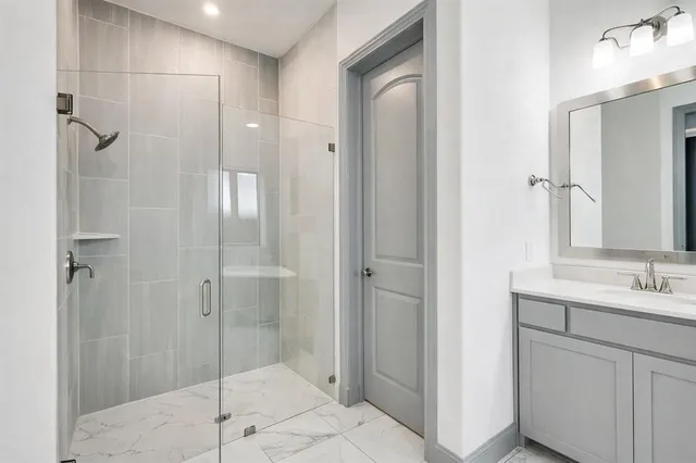 an empty room with windows and chandelier fan