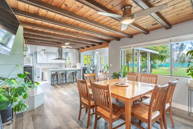 a kitchen with kitchen island granite countertop a sink cabinets stainless steel appliances and a chandelier