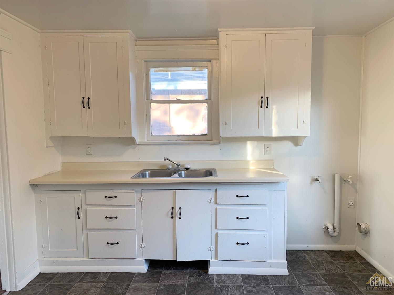 a kitchen with cabinets appliances and a window