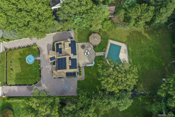 an aerial view of a house with garden space and trees all around