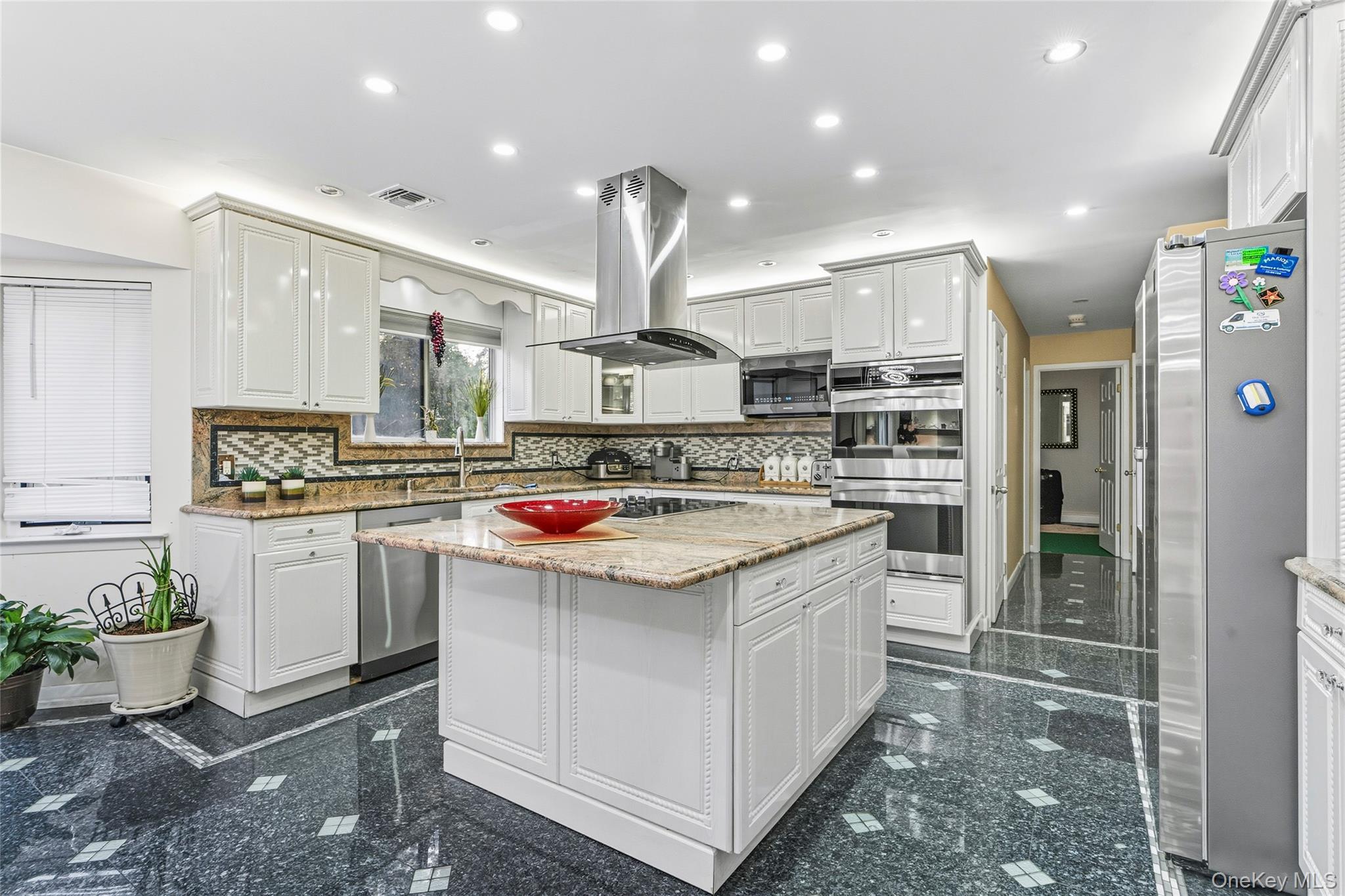 258 Half Hollow Road Dix Hills, NY 11746 - Photo 31 of 45 a kitchen with kitchen island granite countertop a sink stove and refrigerator