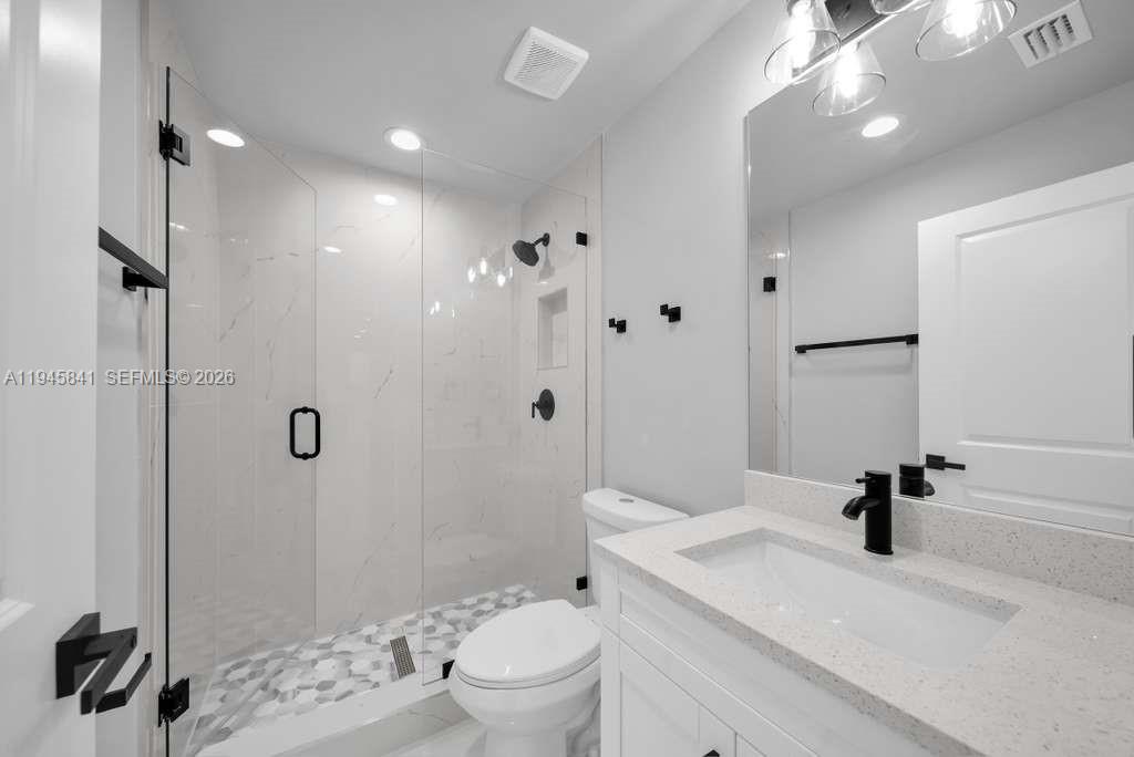 3210 10th Street Southwest, Unit 3210 Lehigh Acres, FL 33976 - Photo 17 of 29 a bathroom with a sink a toilet a mirror and shower