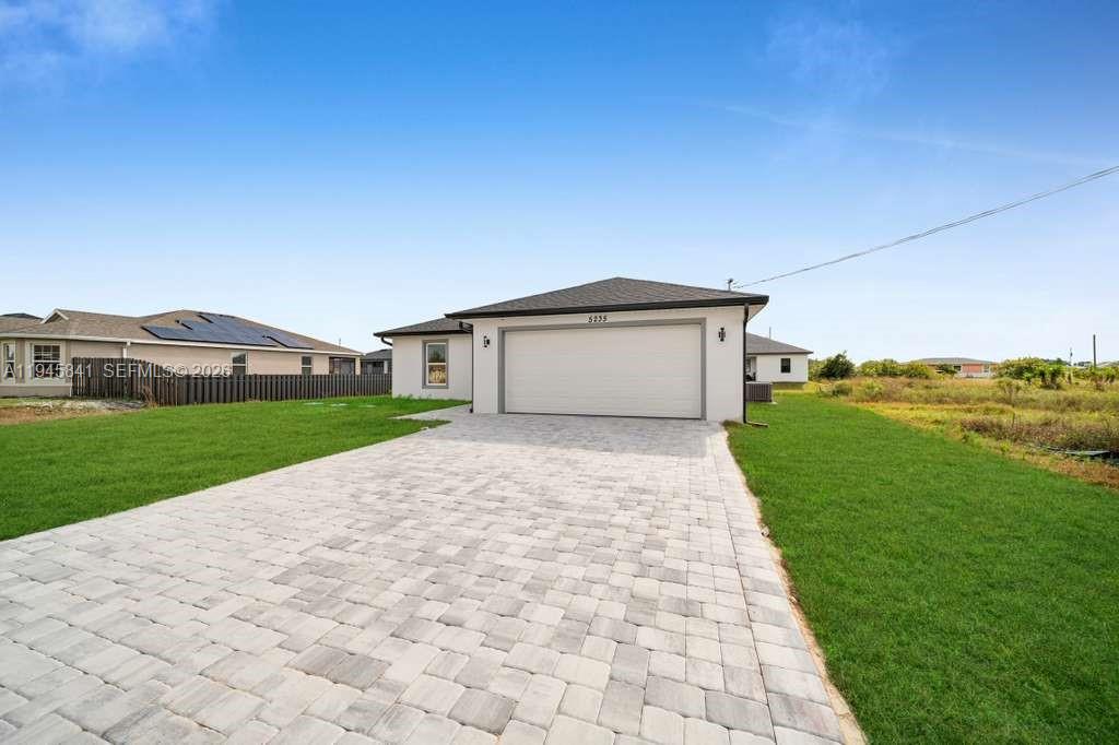 3210 10th Street Southwest, Unit 3210 Lehigh Acres, FL 33976 - Photo 2 of 29 a front view of a house with a yard