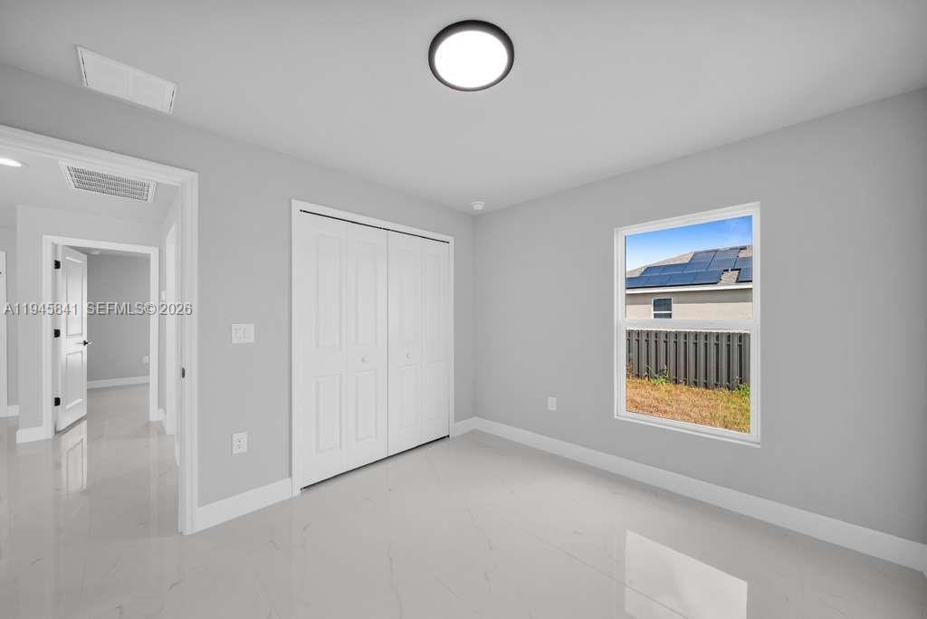 3210 10th Street Southwest, Unit 3210 Lehigh Acres, FL 33976 - Photo 21 of 29 wooden floor and windows in a room