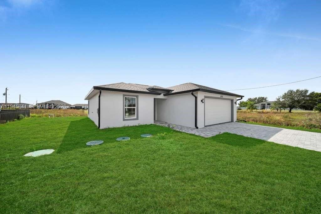 3210 10th Street Southwest, Unit 3210 Lehigh Acres, FL 33976 - Photo 3 of 29 a backyard of a house with plants and large tree