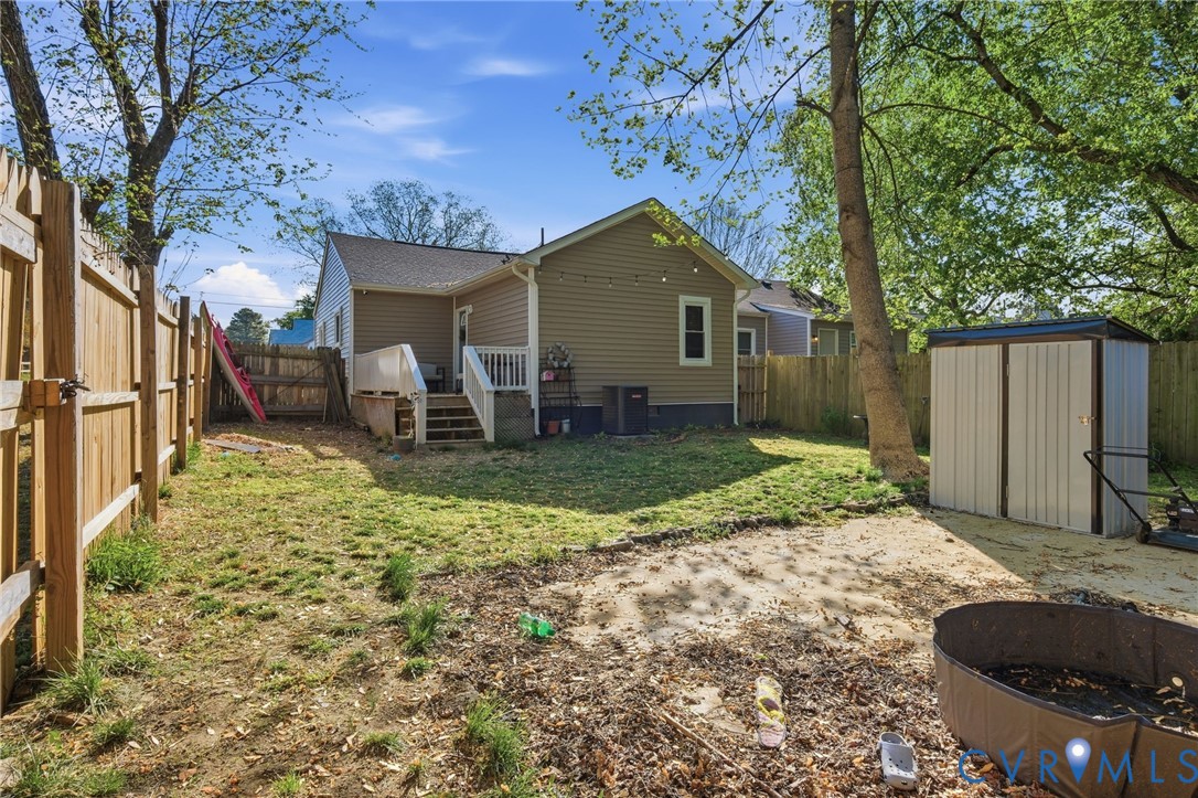 102 Spring Street Petersburg, VA 23803 - Photo 21 of 24 Back of property with a storage unit, a deck, and