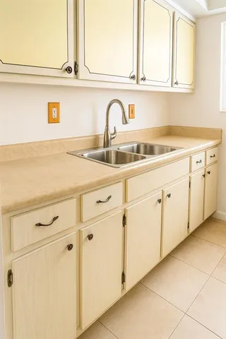 a kitchen with white cabinets and sink