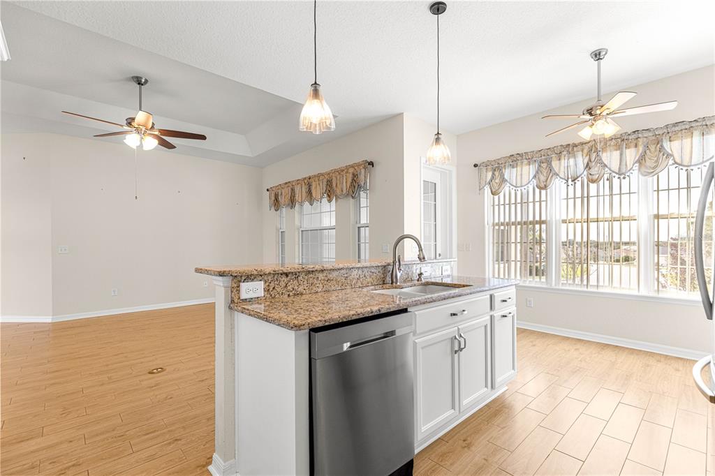 17306 Southeast 112th Court Road Summerfield, FL 34491 - Photo 11 of 42 a kitchen with a stove a sink a chandelier and living room view