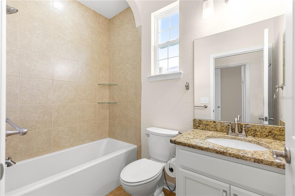 17306 Southeast 112th Court Road Summerfield, FL 34491 - Photo 25 of 42 a bathroom with a granite countertop sink a toilet and bathtub