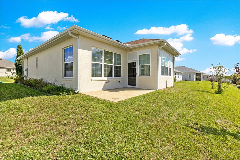 17306 Southeast 112th Court Road Summerfield, FL 34491 - Photo 39 of 42 a front view of a house with a yard and potted plants