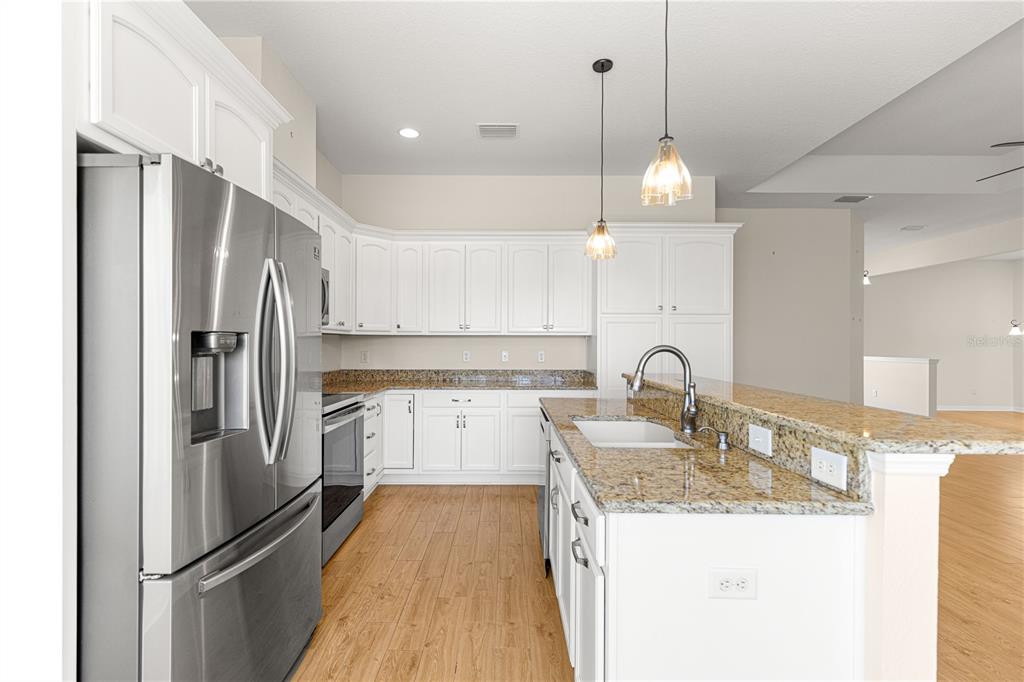 17306 Southeast 112th Court Road Summerfield, FL 34491 - Photo 10 of 42 a kitchen with granite countertop a refrigerator and a sink