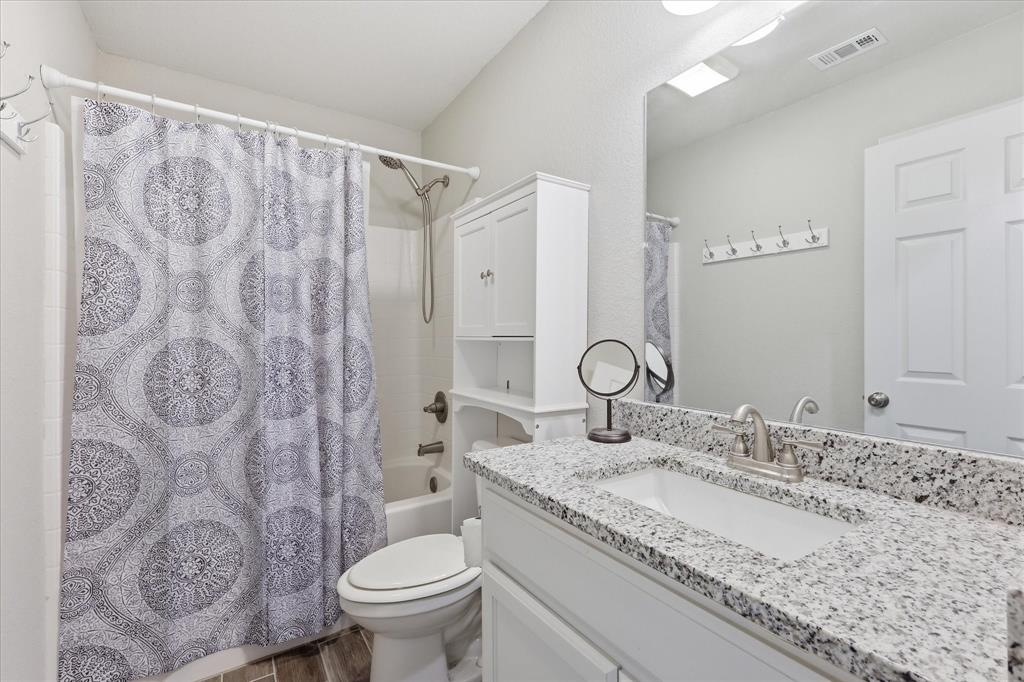 110 Highview Road Ennis, TX 75119 - Photo 23 of 40 Bathroom vanity with a speckled countertop, undermount sink, and brushed nickel faucet
