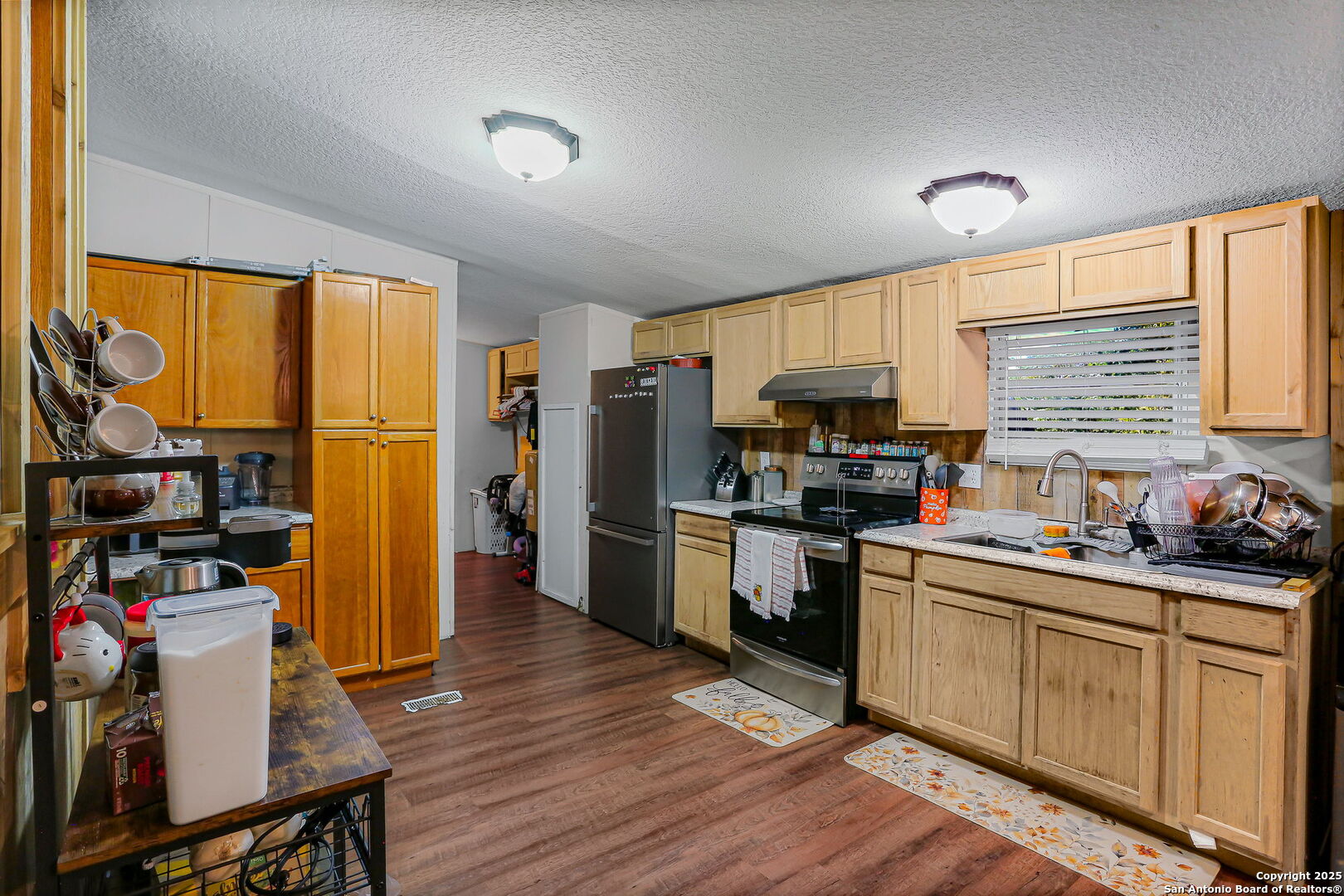 12925 Luckey Road Atascosa, TX 78002 - Photo 16 of 50 a kitchen with granite countertop a refrigerator stove top oven and sink