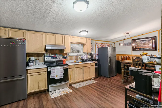 a kitchen with a refrigerator wooden floor and black appliances