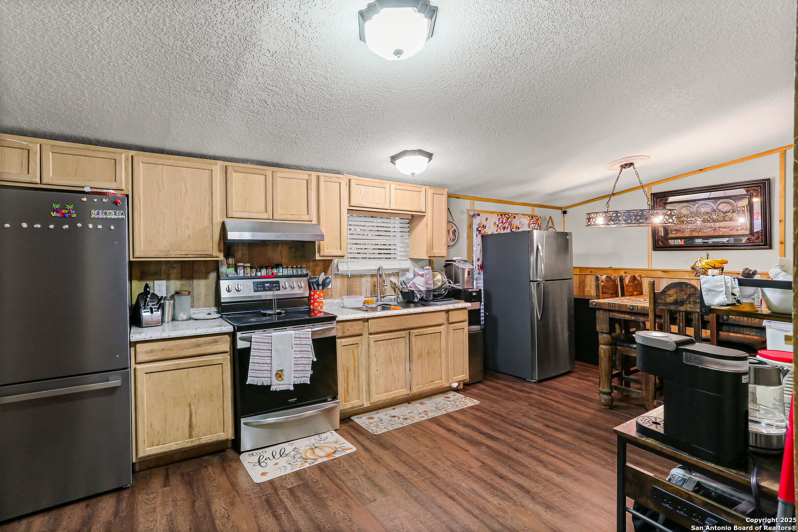 12925 Luckey Road Atascosa, TX 78002 - Photo 17 of 50 a kitchen with a refrigerator wooden floor and black appliances