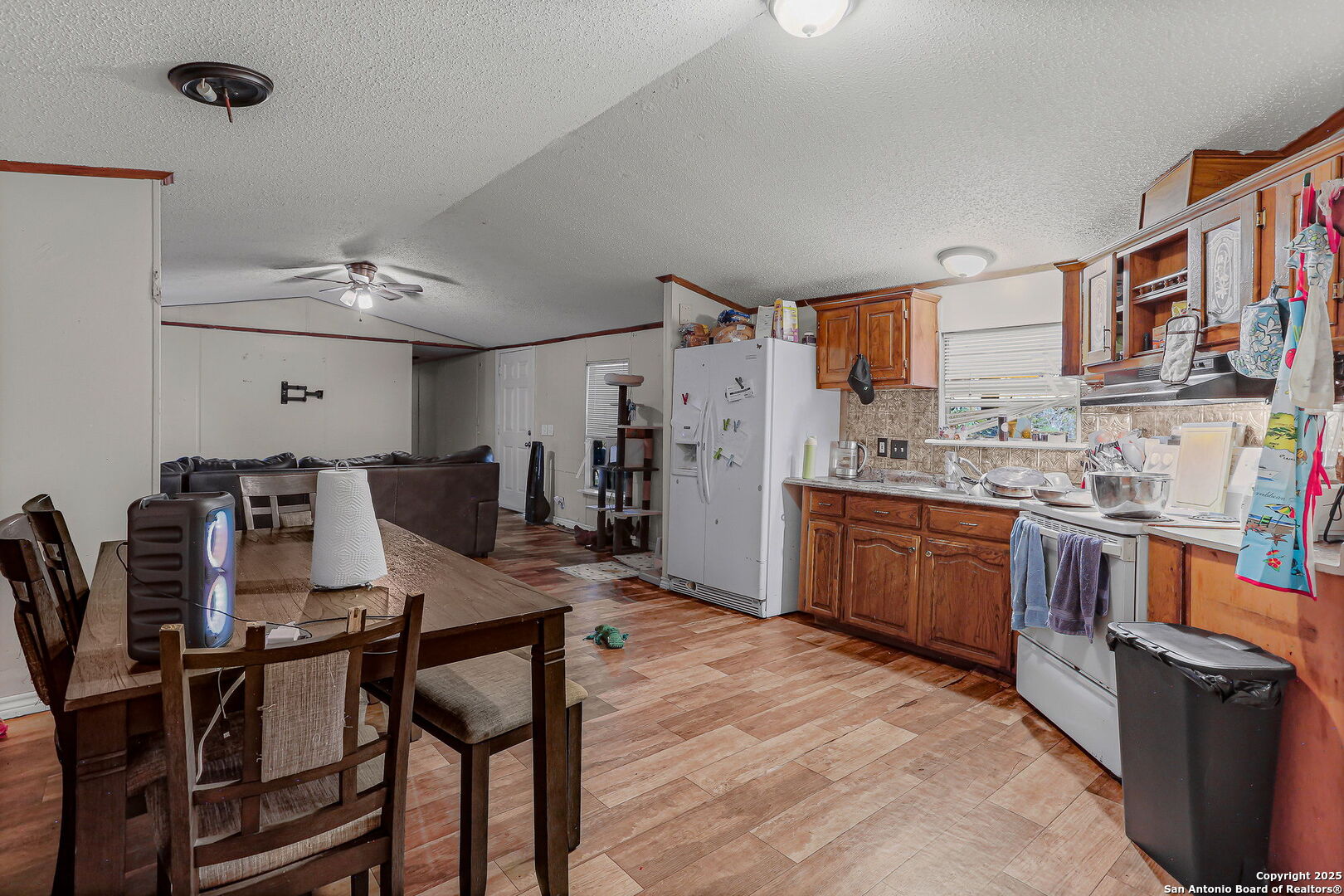 12925 Luckey Road Atascosa, TX 78002 - Photo 29 of 50 a kitchen with stainless steel appliances kitchen island granite countertop a table chairs in it and a refrigerator