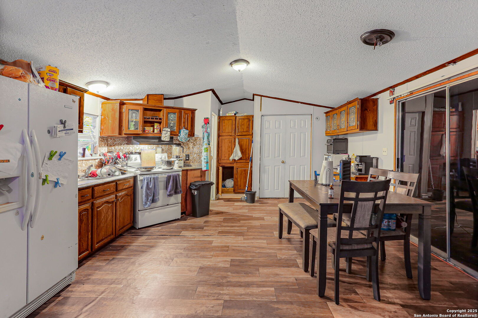 12925 Luckey Road Atascosa, TX 78002 - Photo 31 of 50 a kitchen with stainless steel appliances kitchen island granite countertop a table chairs stove a refrigerator and cabinets
