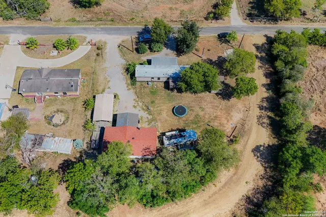 an aerial view of residential house with an outdoor space and tennis court