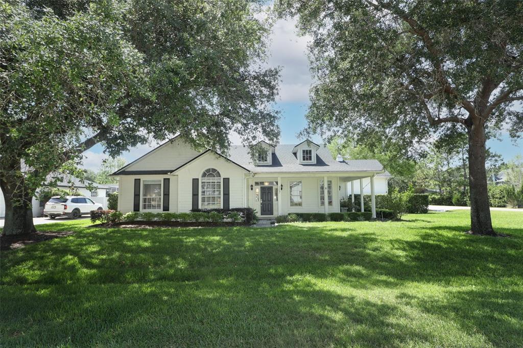 207 Mather Smith Drive Oakland, FL 34760 - Photo 1 of 1 a front view of a house with a garden and trees