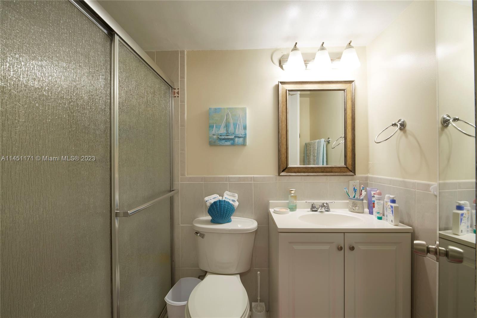 6705 Northwest 169th Street, Unit C205 Hialeah, FL 33015 - Photo 6 of 13 a bathroom with a toilet sink and mirror