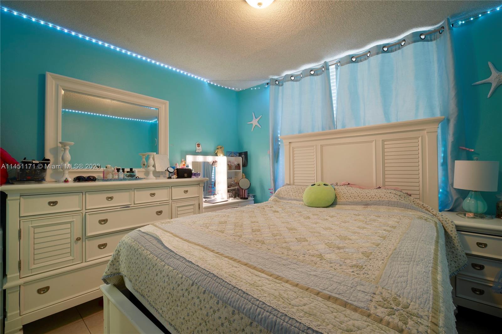6705 Northwest 169th Street, Unit C205 Hialeah, FL 33015 - Photo 9 of 13 a bedroom with a large bed and a dresser
