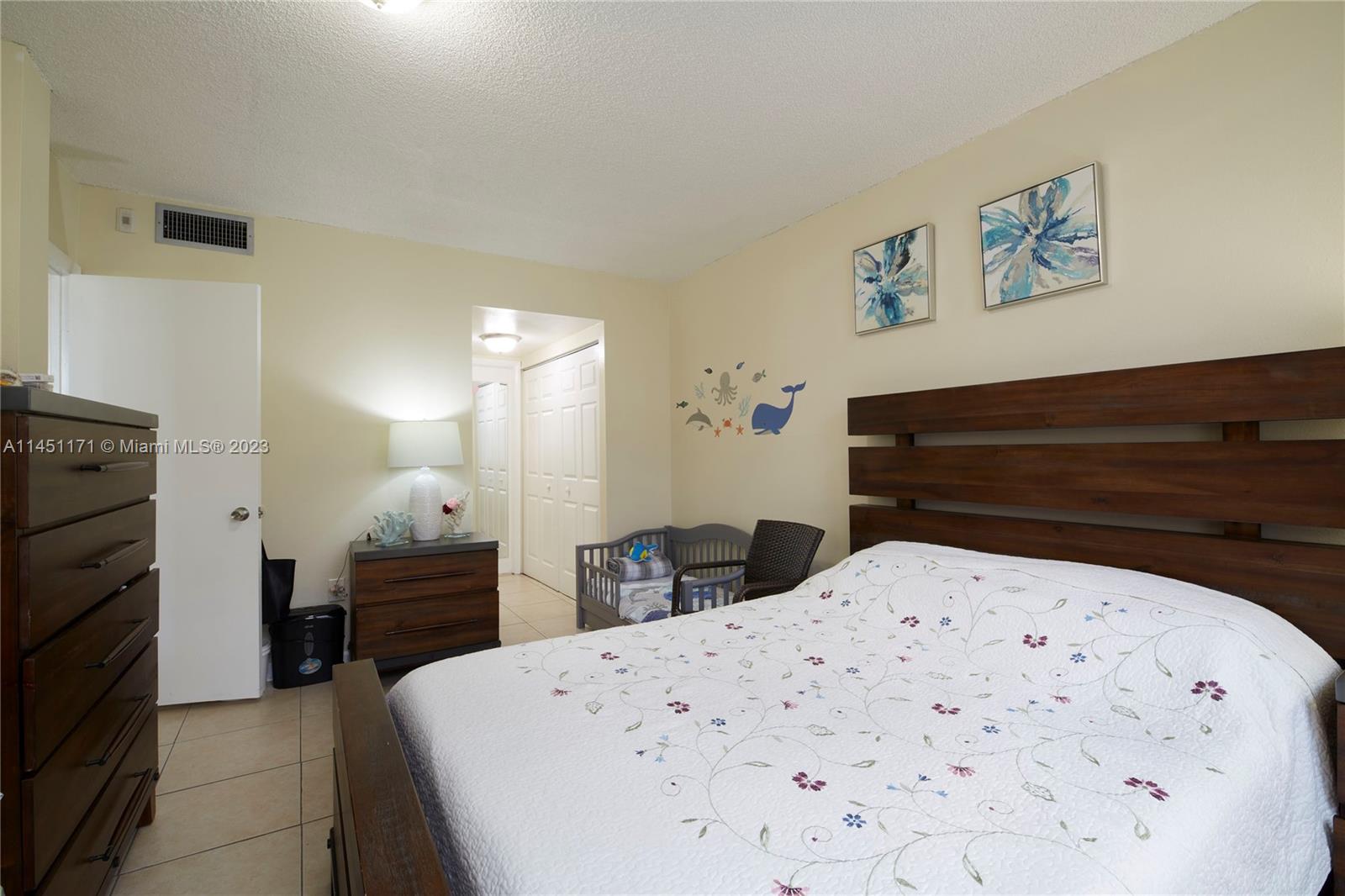 6705 Northwest 169th Street, Unit C205 Hialeah, FL 33015 - Photo 10 of 13 a bed room with a bed and a television