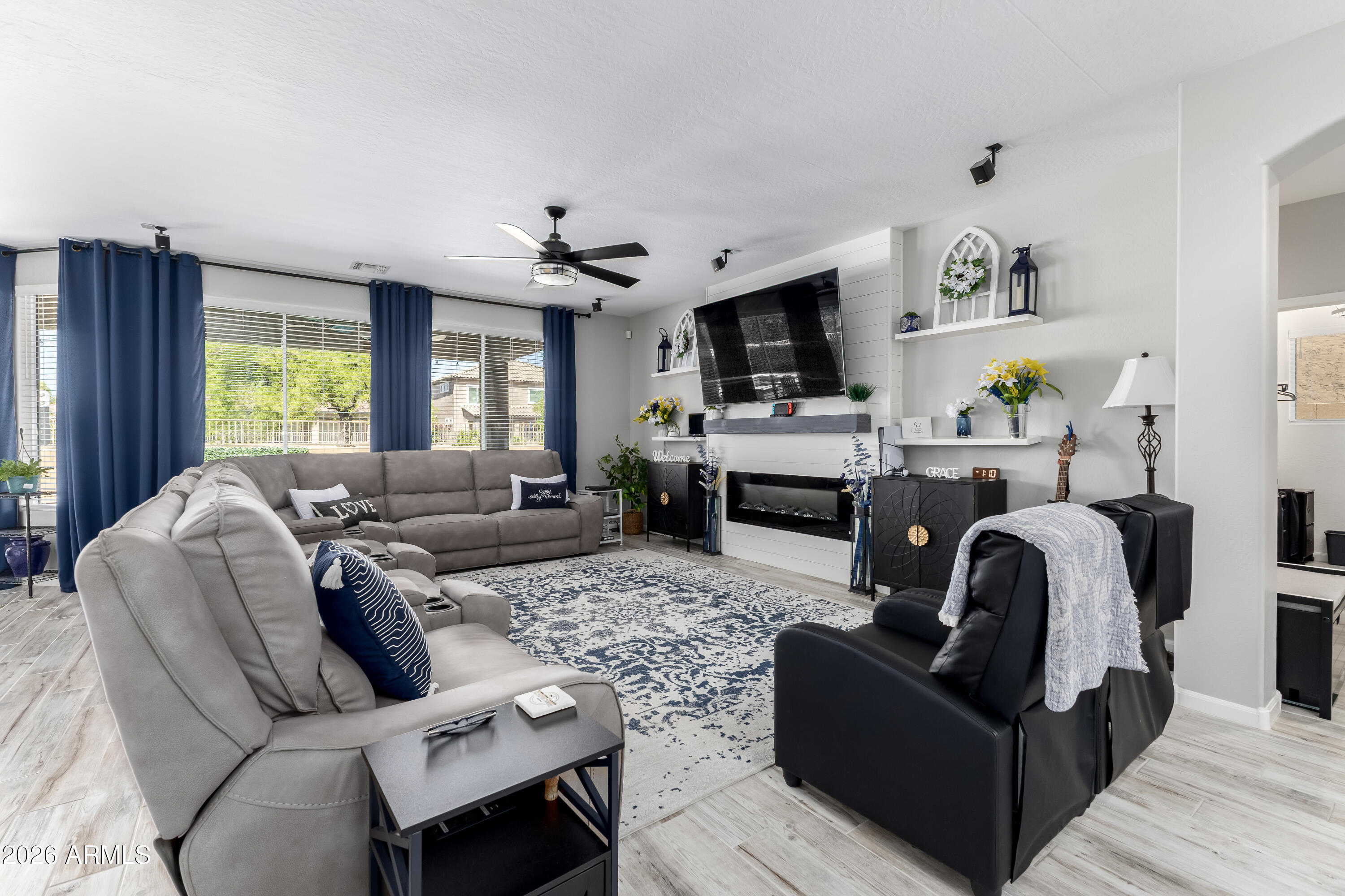3256 East Geronimo Court Gilbert, AZ 85295 - Photo 21 of 53 a living room with furniture a flat screen tv and a fireplace
