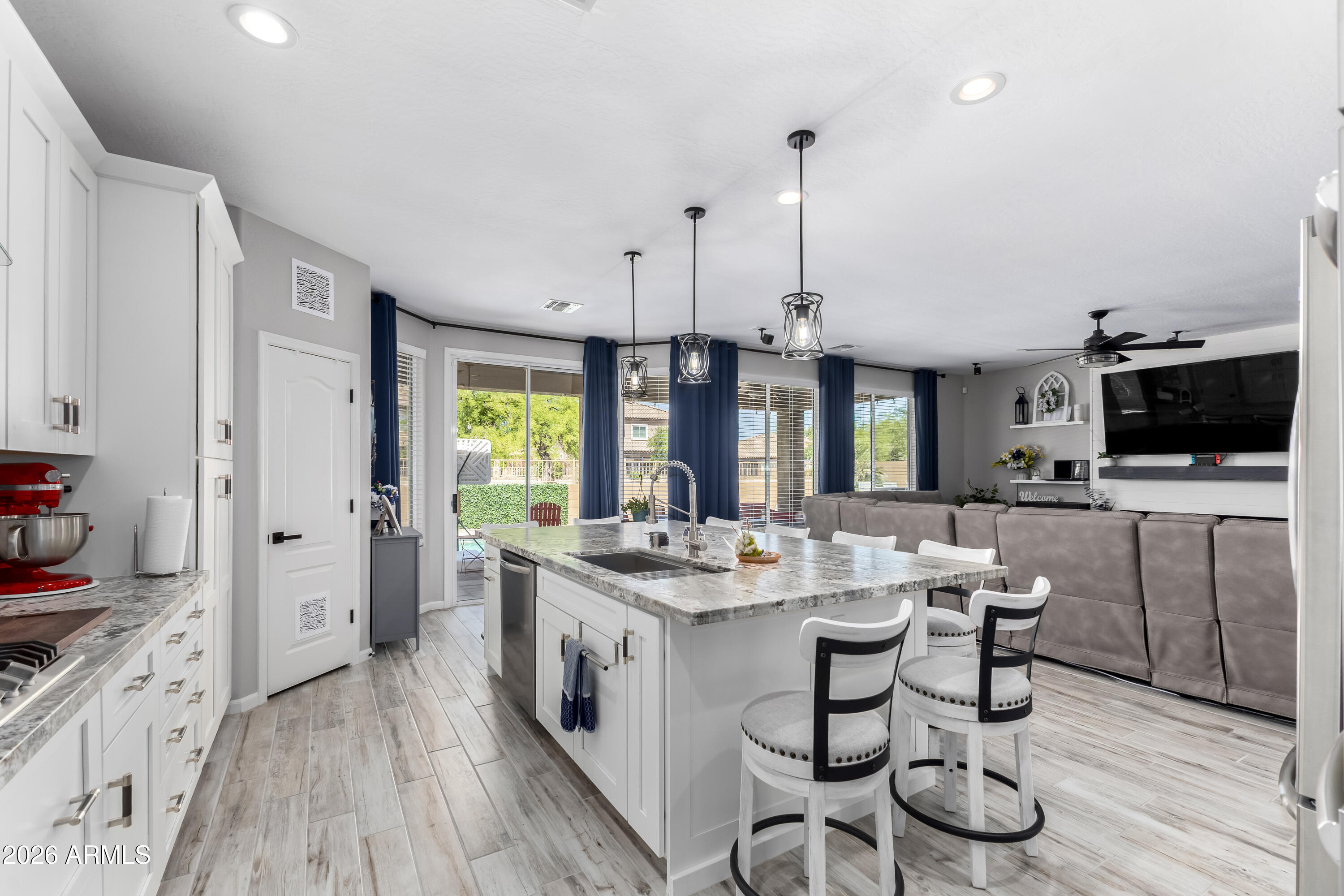 3256 East Geronimo Court Gilbert, AZ 85295 - Photo 25 of 53 a open kitchen with stainless steel appliances granite countertop a stove and a wooden floors