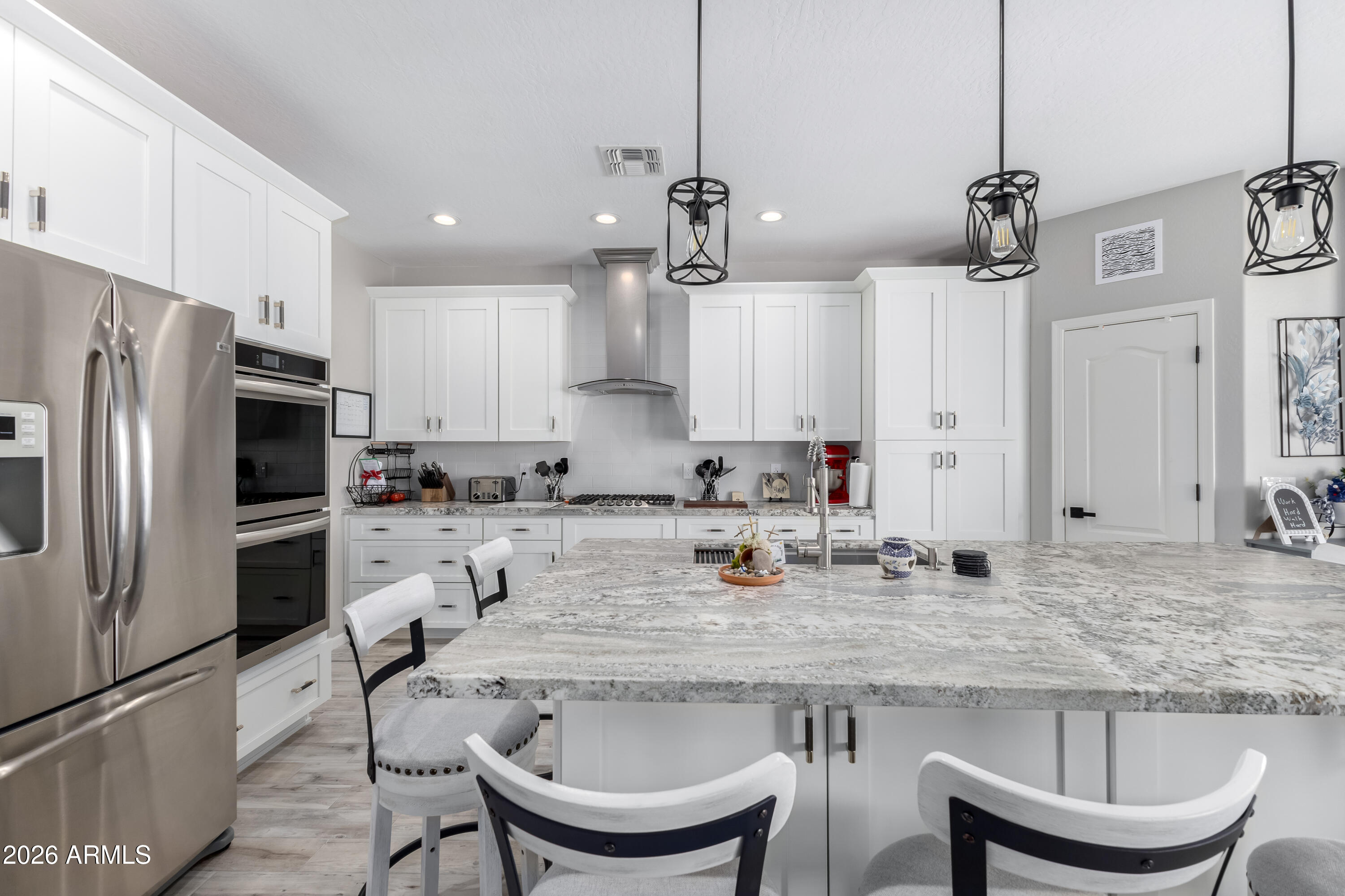 3256 East Geronimo Court Gilbert, AZ 85295 - Photo 26 of 53 a kitchen with stainless steel appliances granite countertop a sink a stove a refrigerator and chairs