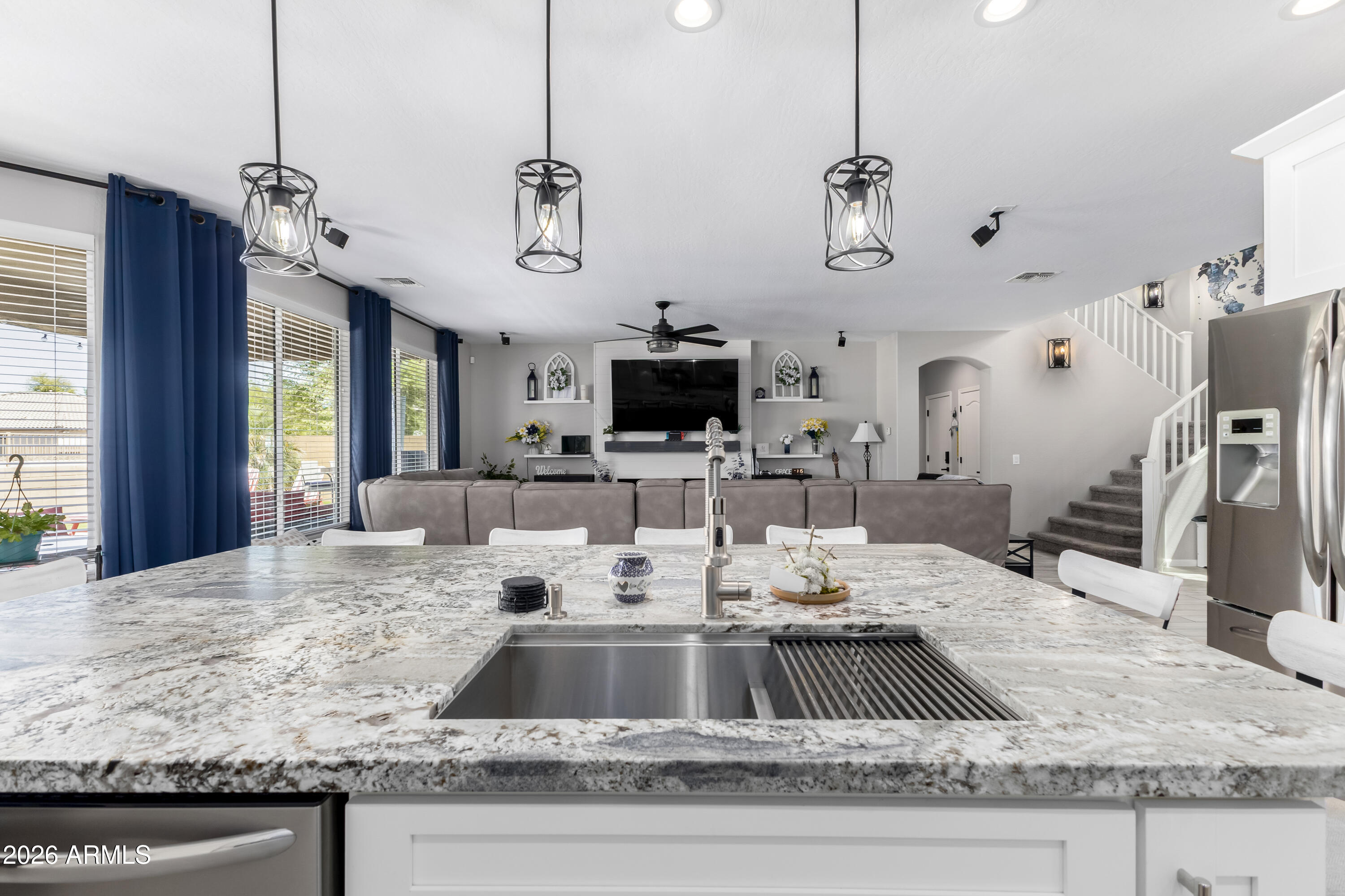 3256 East Geronimo Court Gilbert, AZ 85295 - Photo 29 of 53 a kitchen with kitchen island granite countertop a sink a counter top space cabinets and stainless steel appliances