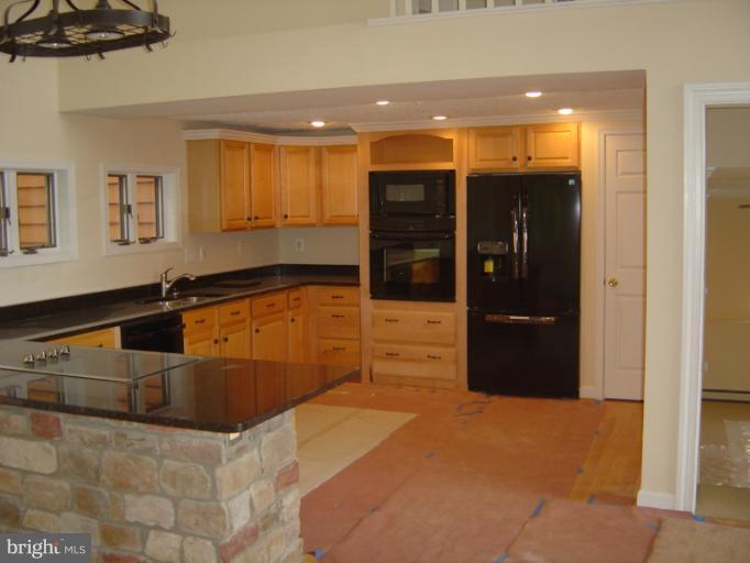 18002 Marshall Mill Road Hampstead, MD 21074 - Photo 15 of 30 a kitchen with stainless steel appliances kitchen island granite countertop a refrigerator and a sink