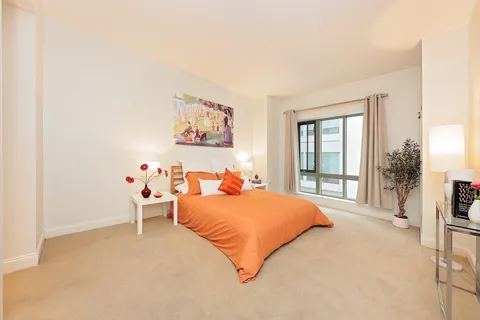 a bedroom with a bed and a large window